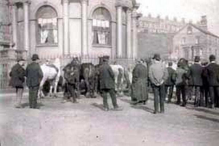 Travellers and horses in front of hotel
